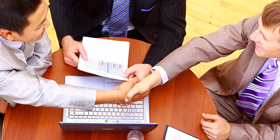 business handshake over workplace